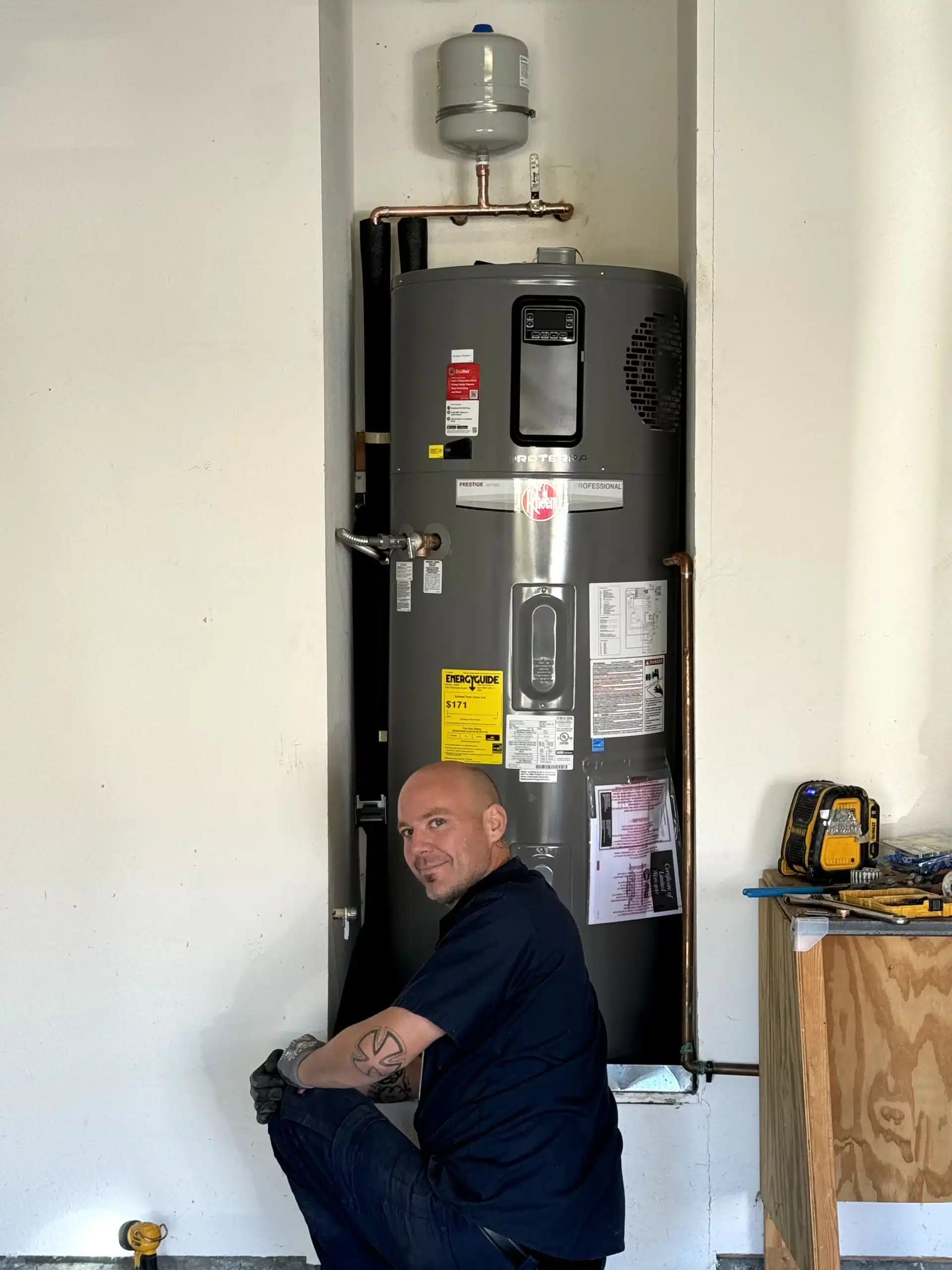 Tech in front of Hybrid electric water heater in residential home in Antioch, Ca.